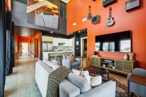 sala de estar con pared de color naranja en The Rhythm and Rooftop Penthouse Walk To Broadway with Pool and Amazing Views, en Nashville
