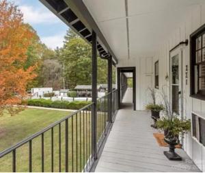 un porche vacío de una casa con balcón en Lakefront Bubbles & Beach, en Flat Rock