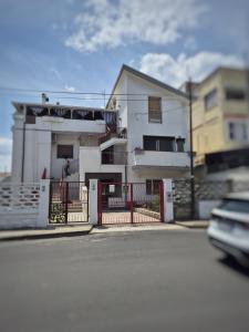 ein weißes Haus mit einem Zaun vor einer Straße in der Unterkunft Bouganville in Ginosa Marina