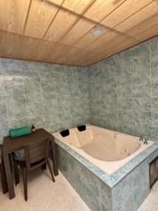 a bath tub in a room with a table and a table sidx sidx at Cabañas Avani in San Francisco