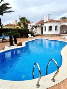 a swimming pool in front of a house at CALA FORN y CLIMATIZADA in Les tres Cales