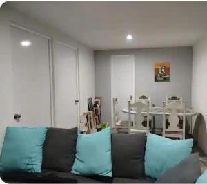 a living room with a brown couch with blue pillows at Departamento Atlixco in Atlixco