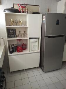 a kitchen with a refrigerator and some trophies at Quarto em apartamento in Caruaru
