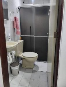 a bathroom with a toilet and a sink and a shower at Quarto em apartamento in Caruaru