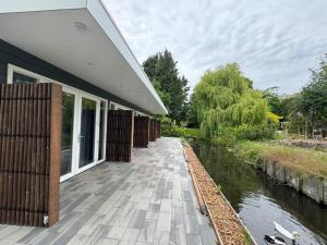 a building with a walkway next to a river at B&B Hu Renesse in Renesse