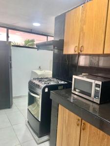 a kitchen with a stove and a microwave at Apto 401 Edificio El Karey in Rodadero +7 photos