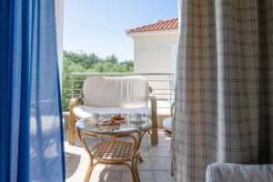 a balcony with a chair and a glass table at Ridomo Sea View Villas Camellia & Jasmine in Avia