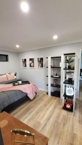 a bedroom with a bed and a wooden floor at Lisle Farm Haven in Pukekohe East