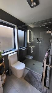 a bathroom with a toilet and a glass shower at Lisle Farm Haven in Pukekohe East +18 photos