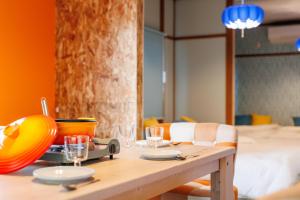 ein Holztisch mit Tellern und Gläsern darauf in der Unterkunft 美瑛ゆめゆめハウス in Biei