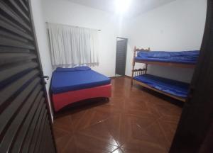 a room with two bunk beds and a refrigerator at Rancho Vô Mário Miguelópolis in Miguelópolis