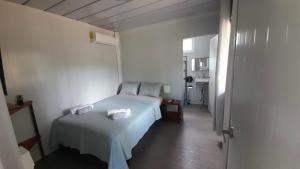 a bedroom with a bed with two towels on it at Apartamentos Equipados DMR #3 in Uvita