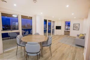 a dining room with a table and chairs and windows at Waterfront- London Greenwich o2 Arena 2 Bed Flat in London