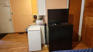 a living room with a television and a small refrigerator at Balgonie Motor Inn in Pilot Butte