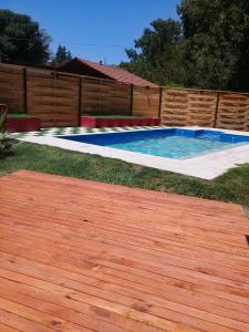 a swimming pool in a yard with a wooden fence at Cabañas entre Bermejo in Guaymallen +10 photos