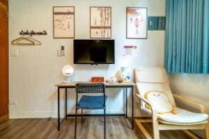 a room with a desk and two chairs and a tv at FuqianRED in Tainan