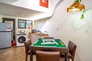 a room with a ping pong table and a kitchen at FuqianRED in Tainan