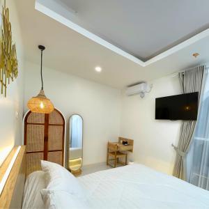 Un dormitorio con una cama y un televisor en la pared. en D'kraton Villa by Dparagon, en Timuran 8 fotos más