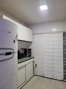 una cucina con pareti bianche e frigorifero di Casa do aconchego cohab1 a Garanhuns