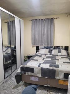 una camera da letto con un letto e un grande specchio di Casa do aconchego cohab1 a Garanhuns