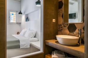 a bathroom with a sink and a bed at Vilos Suites in Pollonia