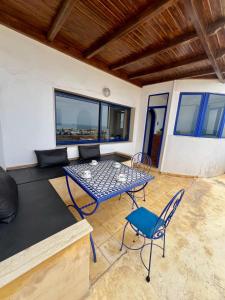 a living room with a table and chairs at Le petit château Vue sur mer Uniquement les familles in Oualidia