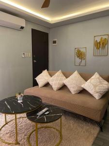 a living room with a couch and two tables at Sinsan Pension House by RH Transient Houses in Bangad