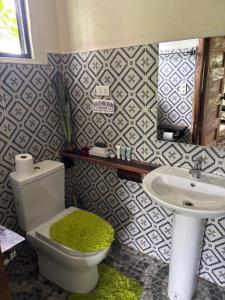 a bathroom with a toilet and a sink at JLB Resort and Tours,Mango Rooms in Valdez +17 photos