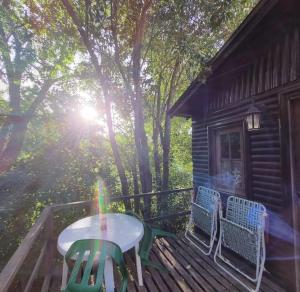 a table and chairs on a deck of a cabin at Cabaña mandala in Tigre