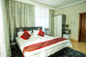 a bedroom with a large bed with red pillows at Hotel Enigma in Khabarovsk