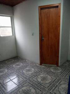 an empty room with a door and a tile floor at casa aconchegante para descansar in Alegrete