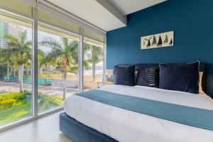 1 dormitorio con 1 cama grande, paredes y ventanas azules en Capitalia Tres Mares Beach Residences & Marina, en Puerto Vallarta 53 fotos más