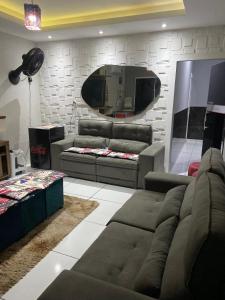a living room with a couch and a mirror at Hotel e Pousada REQUINTTE in Parnaíba