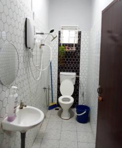 a white bathroom with a toilet and a sink at Delima Guesthouse Type A in Wakaf Baharu +15 photos