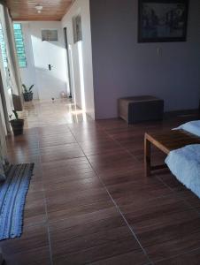a room with a wooden floor with a bench on it at Recanto verde 3 in Alegrete