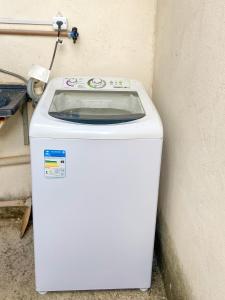 a white washing machine sitting next to a wall at Pousada Acessus Work - Proximo da UniEvangelica e Hospital HEANA in Anápolis