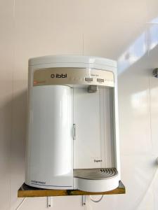 a white appliance sitting on a shelf in a kitchen at Pousada Acessus Work - Proximo da UniEvangelica e Hospital HEANA in Anápolis +16 photos
