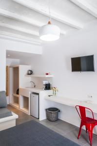 a living room with a red chair and a sink at Vilos Suites in Pollonia