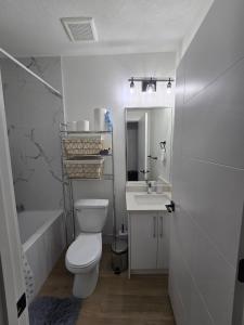 a white bathroom with a toilet and a sink at Amazing 2-bedroom house with WiFi in Edmonton in Edmonton