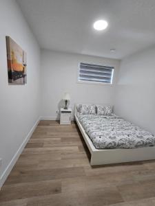 a white bedroom with a bed and a night stand at Amazing 2-bedroom house with WiFi in Edmonton in Edmonton +30 photos