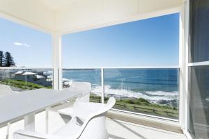 una sala da pranzo bianca con vista sull'oceano di Avalon 3 a Yamba