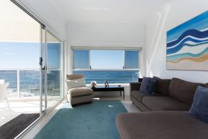 a living room with a couch and a view of the ocean at Avalon 3 in Yamba