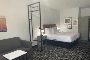 a hotel room with a bed and a couch at La Quinta Inn & Suites by Wyndham Olive Branch in Olive Branch +7 photos