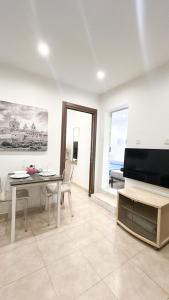 セントジュリアンズにある100m from Paceville Apartmentのテーブルとテレビのあるリビングルーム
