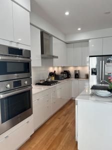a kitchen with white cabinets and stainless steel appliances at Best Choice for Travellers in Toronto