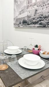 a table with white plates on top of it at 100m from Paceville Apartment in St. Julianʼs +10 photos