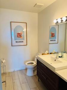 Un baño con inodoro, lavabo y espejo. en Le familial 9 personnes, en Beaupré