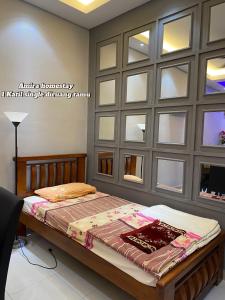 a bedroom with a bed with a wall of windows at Amira homestay in Kampong Batu Lima