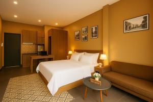 a hotel room with a bed and a couch at Ben's Premier Hotel & Apartment - Hanoi Center in Hanoi