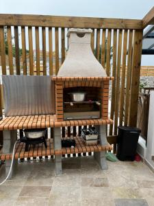 a wooden bench sitting on a deck with a grill at Les panoramiks des Makes in Saint-Louis